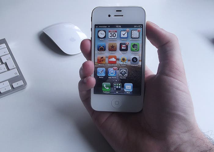 iPhone 4 blanco sujetado por una mano