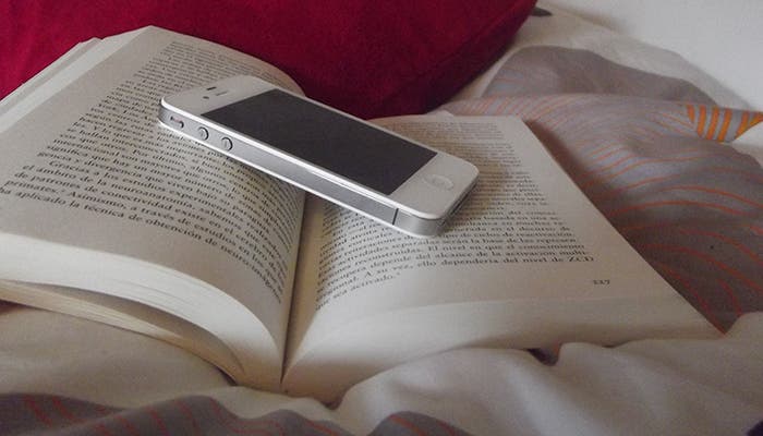 iPhone 4 blanco posado sobre un libro